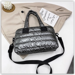 Detail view of silver quilted tote bag featuring metallic finish and detachable black strap