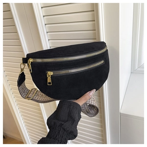 Detail of black suede saddle bag with dual gold zippers and ethnic patterned strap