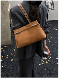 Sac fourre-tout en daim marron avec bandoulières réglables porté à l'épaule à l'extérieur