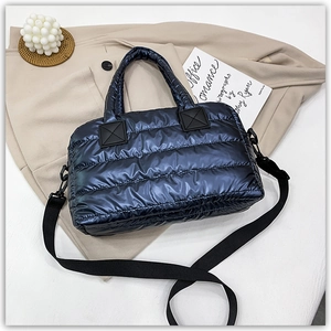 Detail of navy blue quilted tote bag with reinforced handles and removable shoulder strap