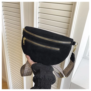 Close-up of black matte saddle bag featuring gold metal zippers and geometric wide strap