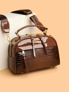 Détail du sac à main marron effet croco avec zips dorés et bandoulière en toile fashion
