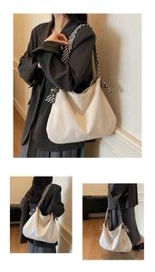Detail of off-white canvas tote bag featuring stylish black and white striped shoulder straps