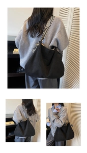 Close-up of black oversized shoulder bag with decorative black and white striped strap