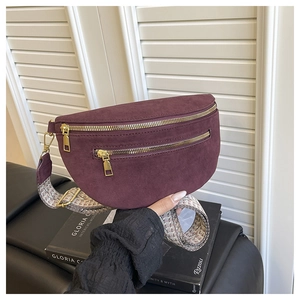 Detail of burgundy faux suede waist bag with gold zippers and ethnic woven strap