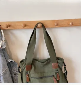 Détail du sac en velours côtelé vert armée avec fermetures éclair et touches de cuir