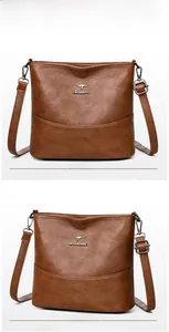 Detail view of brown woven bucket bag with leather texture and adjustable shoulder strap
