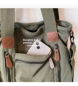 Détail d'un sac en velours vert avec une poche zippée durable et une grande capacité interne