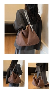 Detail of hobo bag featuring brown suede texture and a striped ribbon bow shoulder strap