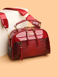 Détail du sac carré en cuir verni rouge avec texture crocodile et logo FASHION doré