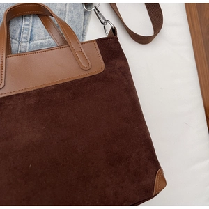 Dettaglio della borsa vintage in pelle scamosciata marrone con tracolla in tessuto