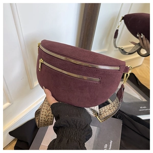 Detail of burgundy suede fanny pack with golden zippers and ethnic jacquard wide strap