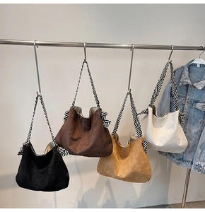 Detail of suede tote bags in four colors with striped straps and side bow accents