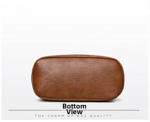 Detail showing the oval bottom of the brown leather bucket bag with precise stitching