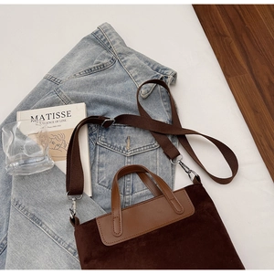 Dettaglio della borsa tote in pelle scamosciata marrone scuro con manici in pelle