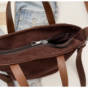 Dettaglio borsa shopper in camoscio marrone con cerniera in metallo e tracolla in pelle PU