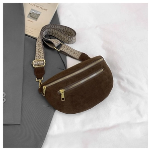 Detail of dark brown suede saddle bag with dual gold zippers and woven pattern strap