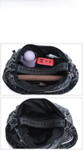 Detail showing the denim crossbody bag's large capacity with three separate zipper compartments