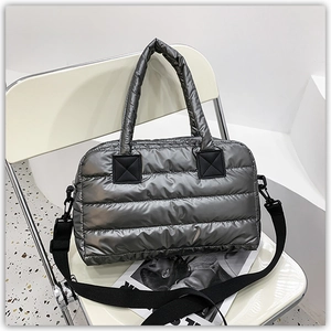 Macro view of metallic grey quilted down tote bag with nylon handles on an accent chair