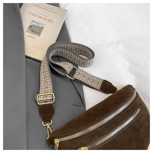 Detail of brown suede crescent bag featuring double zippers and retro woven wide strap
