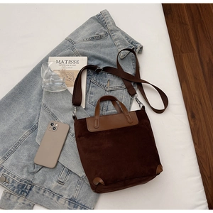 Dettaglio della borsa tote in pelle scamosciata marrone scuro con rinforzi in pelle e tracolla
