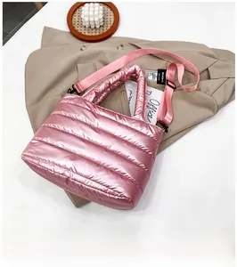 Detalle del bolso acolchado rosa metalizado con correa ajustable y diseño brillante