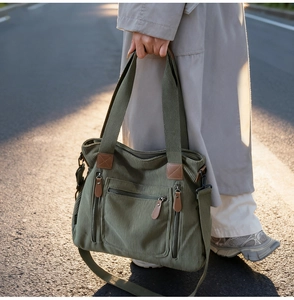 Détail du sac fourre-tout en velours côtelé vert foncé avec poches et accents en cuir brun
