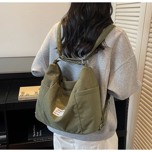 Detailansicht der großen dunkelgrünen Cordtasche mit Textur und praktischen Seitentaschen