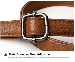 Detail of adjustable brown leather shoulder strap with high-quality dark grey metal buckle