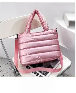 Detalle del bolso acolchado rosa en nailon impermeable con correa y hebillas metálicas