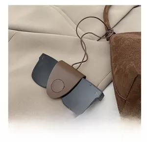 Detail eines Brillenetuis aus braunem Leder an einer passenden Wildlederhandtasche
