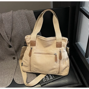 Détail du sac fourre-tout en velours beige avec poches zippées et finitions en cuir brun