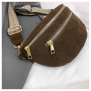 Detail of brown suede crescent bag with dual gold zippers and vintage jacquard strap