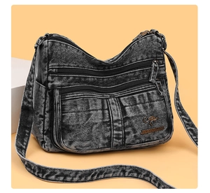 Detail of washed denim shoulder bag with multi-layer zippers and kangaroo metal logo