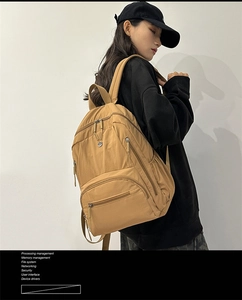 Close-up of khaki nylon travel backpack with multiple pockets and sturdy top handle