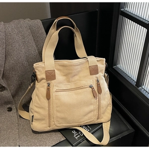 Détail d'un sac cabas en velours côtelé beige avec poches zippées et tirettes en cuir marron