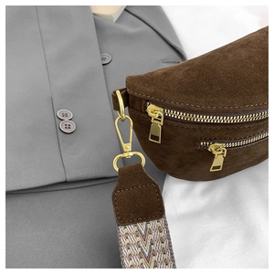 Detail of dark brown suede fanny pack featuring gold zippers and geometric woven strap