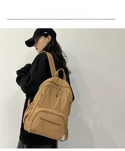 Side view of khaki nylon travel backpack with multiple pockets on a model