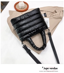 Detalle de bolso shopper acolchado negro con correa de hombro desmontable y asas