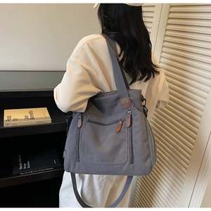 Détail du grand sac cabas en velours côtelé gris avec finitions en cuir et sangle