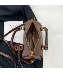 Détail du sac Boston marron foncé avec fermeture éclair et doublure rayée élégante
