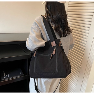 Détail du grand sac cabas en velours côtelé noir avec des accents de cuir marron élégants