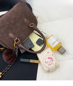 Vue détaillée du sac Boston en daim marron montrant un intérieur spacieux pour les objets