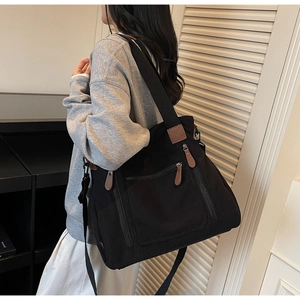 Détail du sac fourre-tout en velours côtelé noir avec zip en cuir et bandoulière