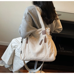 Gros plan du sac en velours côtelé beige montrant le tissu texturé et les détails en cuir