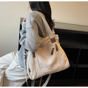 Détail du sac bandoulière en velours côtelé crème avec fermeture éclair en cuir marron