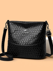 Minimalist black woven bucket bag with metallic logo and adjustable crossbody strap