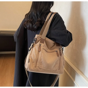 Détail d'un sac cabas en velours côtelé kaki montrant la texture et les poches zippées