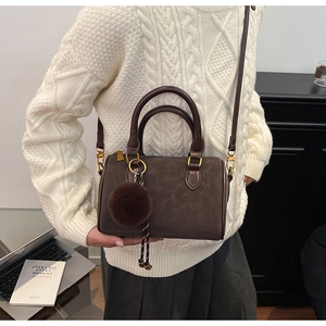 Sac Boston vintage marron avec pendentif en peluche et texture en daim élégante