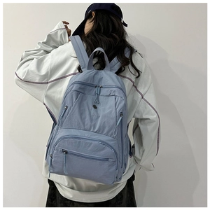Detail of grey-blue nylon backpack with multi-pocket design and waterproof texture